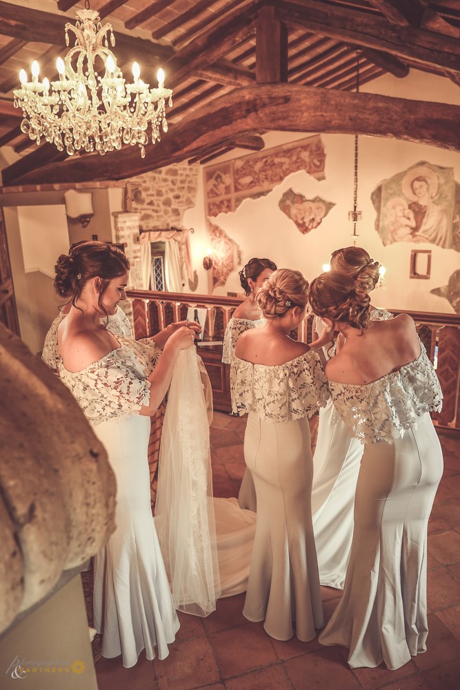 The bridesmaids help the bride with the wedding dress...